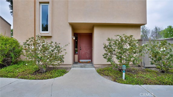 Front view of a house entrance with a narrow window and pathway.