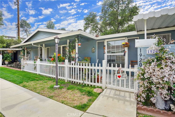 Front view of a single-story house with a white picket fence and covered porch.