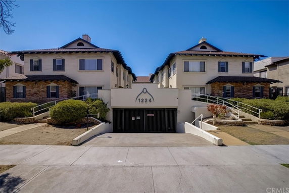 Front view of a two-story apartment building with a central garage entrance.