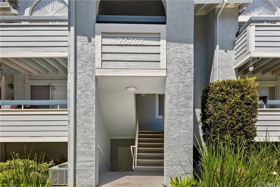 Front view of a building with an entrance staircase and balconies.