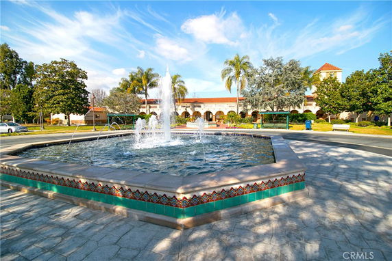 Front view of a structure with arches and a fountain in the foreground.