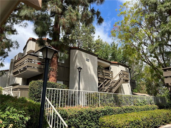 Front view of an apartment building with balconies and staircases.