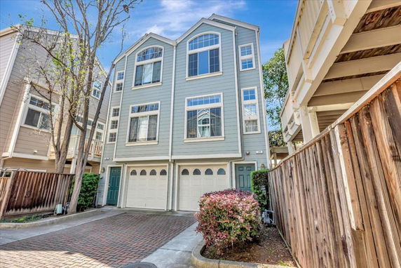 Front view of a multi-story townhouse with garages.