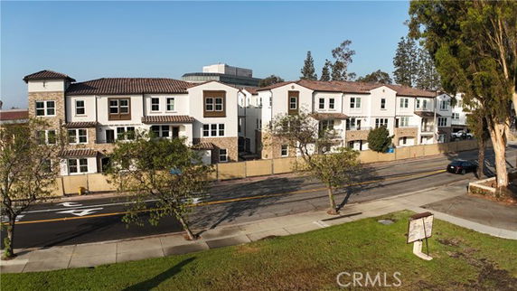 Front view of a row of modern multi-story townhouses along a street.