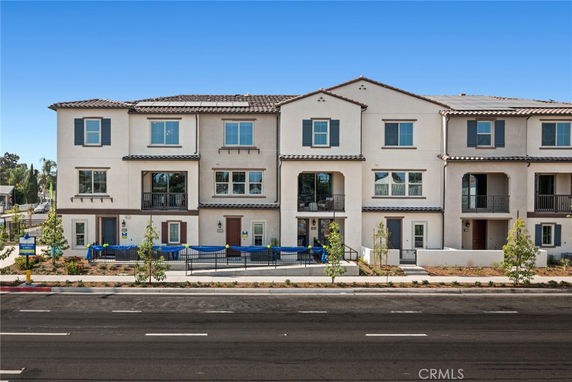 Front view of a multi-story townhouse with multiple balconies.