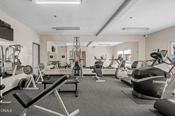 Indoor gym area with exercise equipment and mirrors.