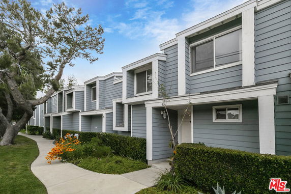 Front view of a row of modern townhouses with blue siding and large windows.