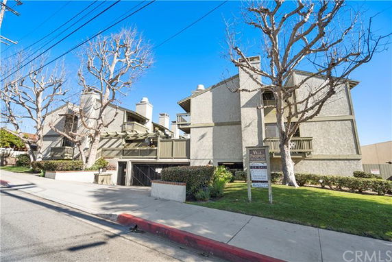 Front view of a multi-story residential building with balconies and chimneys.