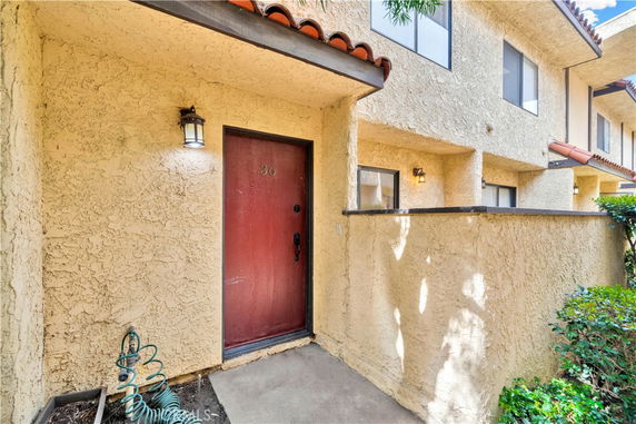 Front view of a residential entrance with a red door and textured walls.