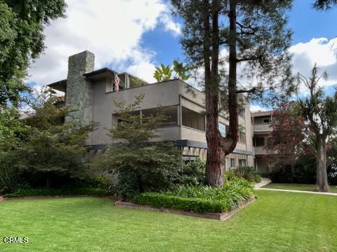 Front view of a two-story building with large windows and a stone chimney.