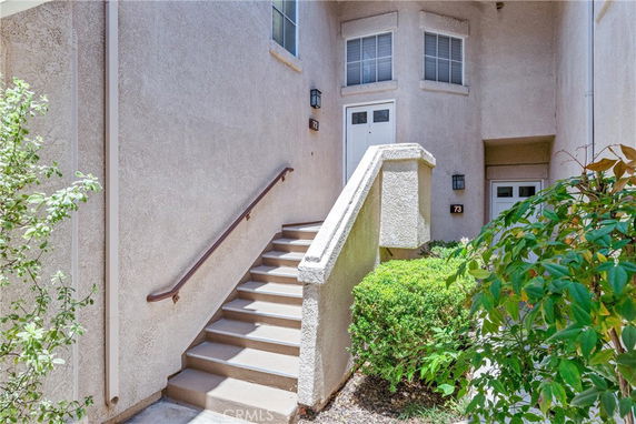 Entrance with stairs leading up to a second-story apartment door