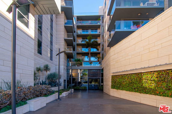 Front view of a multi-story building with balconies and modern design.