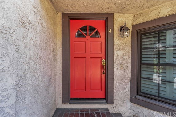 Front view of house entrance with a red door.