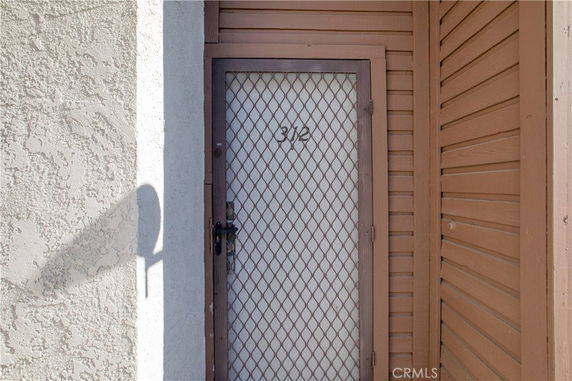 Entrance to a building with a mesh door and number 312.