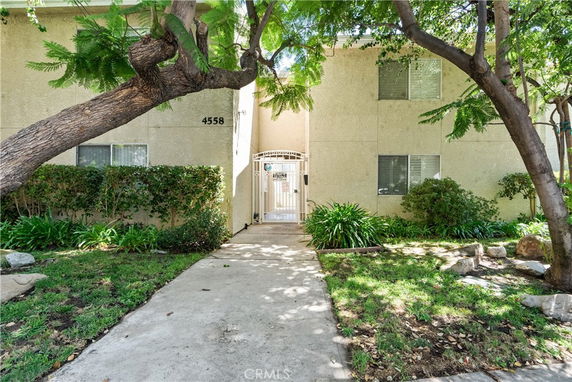 Front view of a two-story apartment building with gated entrance.