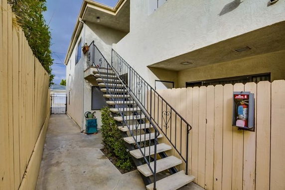 Exterior view of a building with outdoor staircase leading to the upper level.