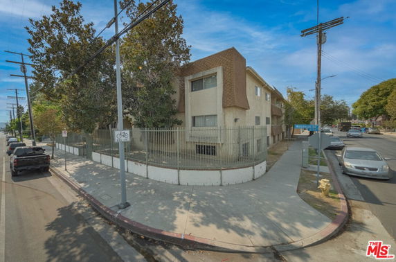 Front view of a multi-story building with a fenced perimeter.