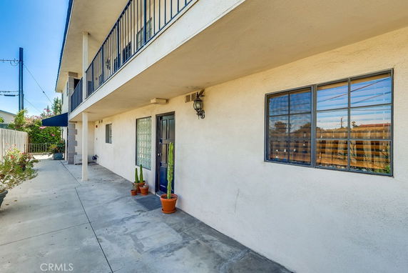 Front view of a two-story building with a balcony and glass windows.