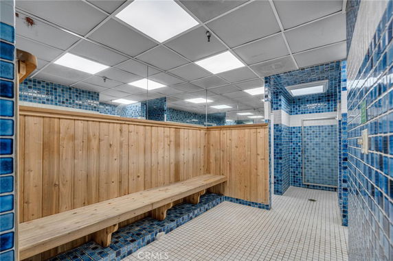 Indoor sauna area with wooden benches and blue tiled walls.