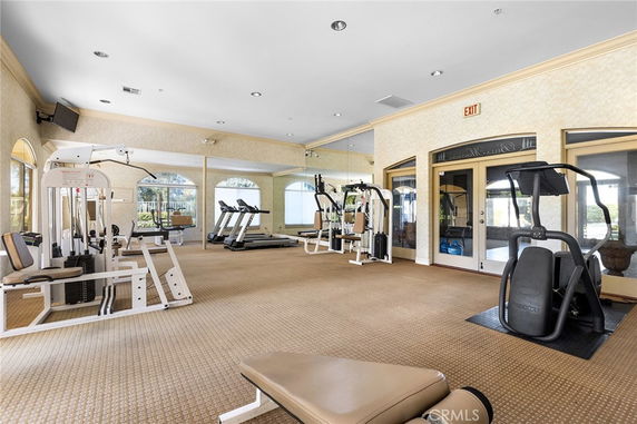 Interior view of a gym with exercise equipment and large windows.