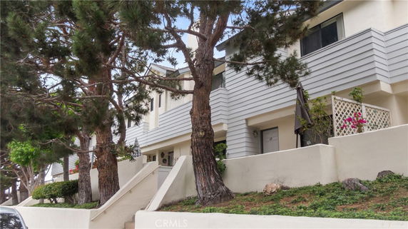 Front view of a multi-story building with trees in front.