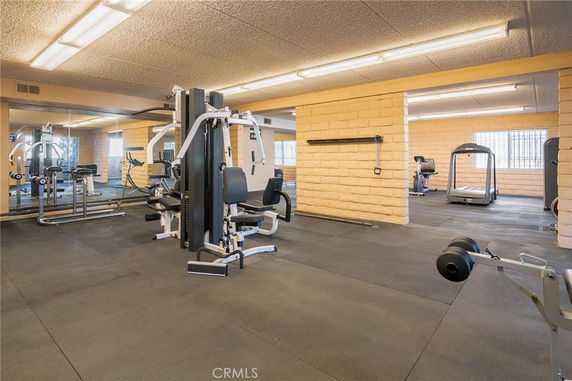 Gym area with exercise equipment including treadmills and weight machines.