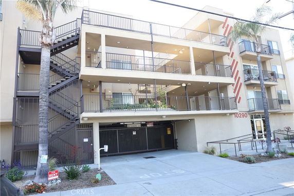 Front view of a multi-story apartment building with balconies.