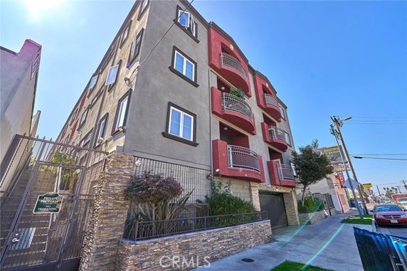 Front view of a multi-story residential building with balconies.