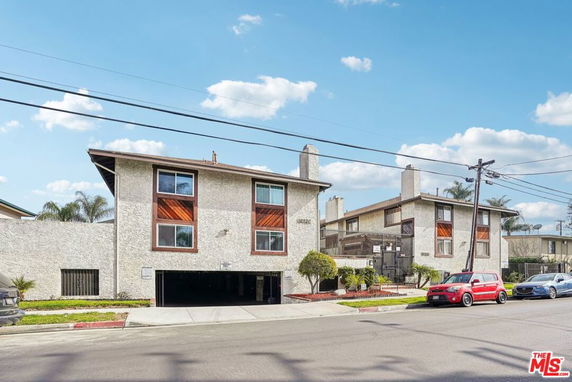 Front view of a multi-story residential building with parking access.