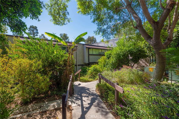 Front view of a house surrounded by lush greenery.