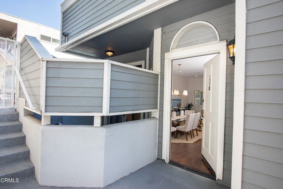 Front view of a house entrance with blue siding and a small balcony.