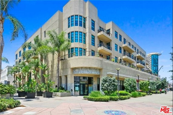 Front view of a multi-story commercial building with balconies and large windows.