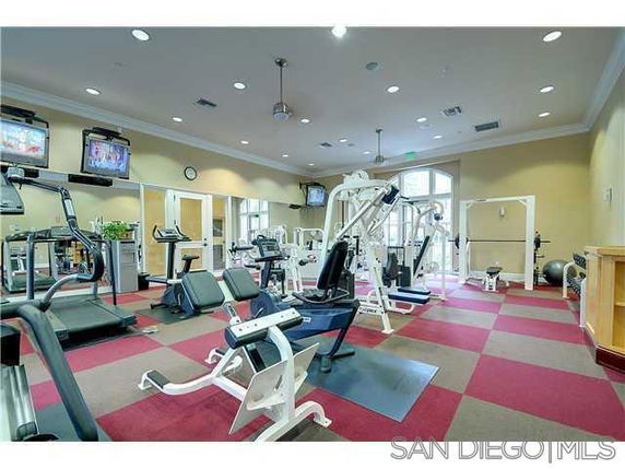 Indoor gym area with various exercise equipment and televisions.