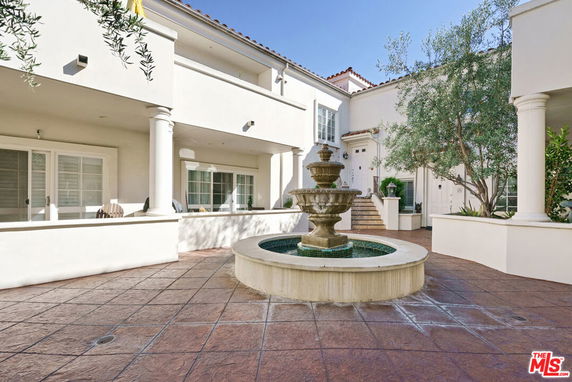 Front view of a two-story house with a central fountain and columns.