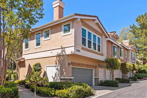 Front view of a two-story house with multiple garages and large windows.