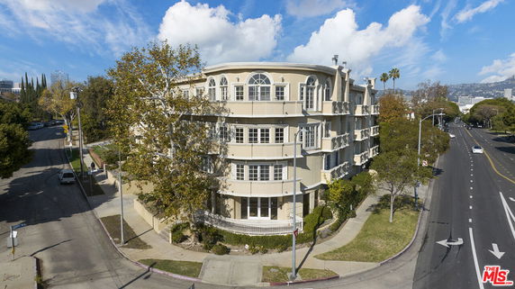 Front view of a multi-story building on a street corner.
