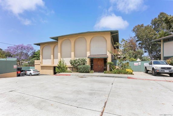 Front view of a house with arched window designs and a covered entrance.