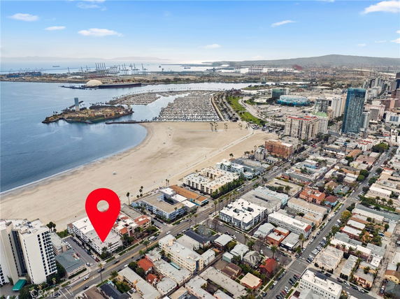 Wide aerial view of coastal cityscape with buildings, beach, and ocean.