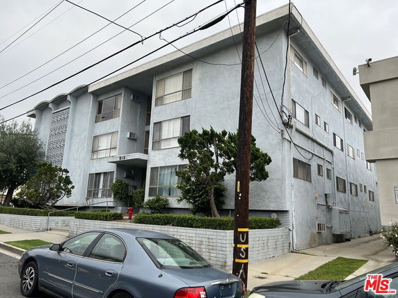 Front view of a multi-story apartment building with a flat roof.
