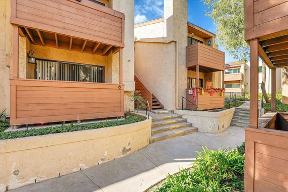 Front view of a multi-story residential building with wooden balcony enclosures.