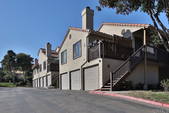Front view of multi-story townhouses with garages.