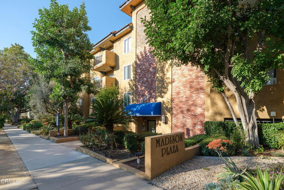 Front view of a multi-story building with balconies and a brick facade.