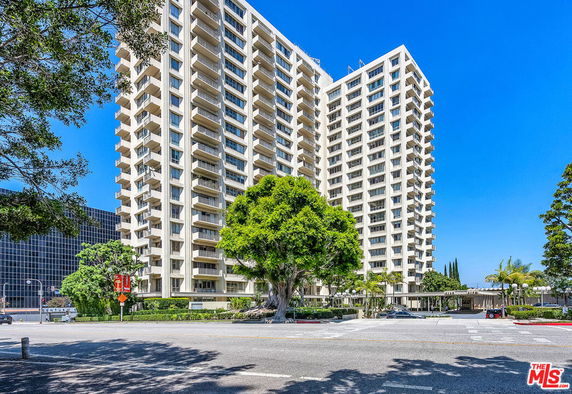 Front view of a high-rise residential building with multiple balconies.