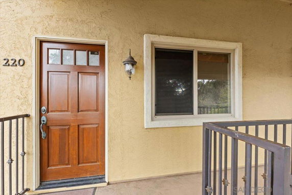 Front view of a house entrance with a wooden door and window.
