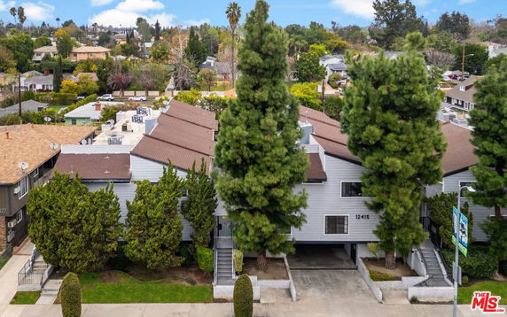 Front view of a residential multi-story building with trees.