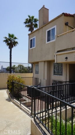 Front view of a two-story building with a fenced patio area.