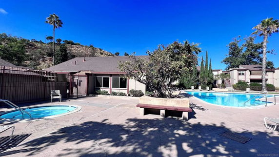 Outdoor swimming area with a pool and surrounding patio.