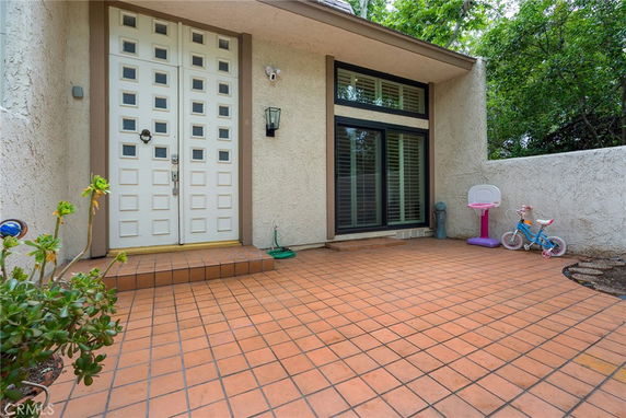 Front view of a house with white double doors and large windows.