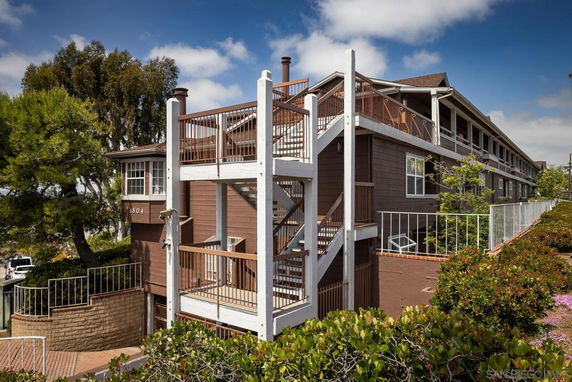 Front view of a multi-story apartment building with external staircases.