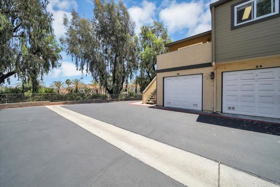 Outdoor parking area in front of a building with two garage doors.